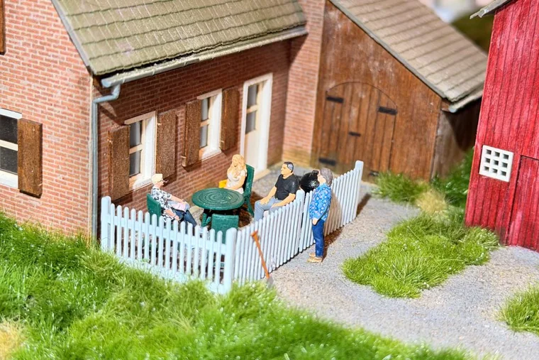 Figuren am Gartentisch vor dem Haus